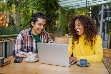 Attractive young multiethnic couple outdoors using laptop