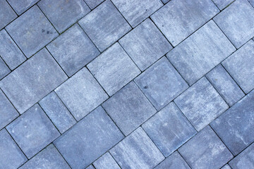 Gray paving stones road. Paving surface road. Texture made of big gray cement bricks