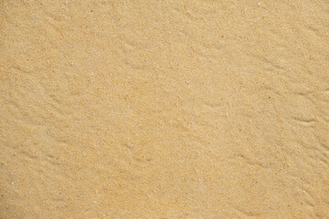 Texture of coarse yellow sand on the beach. Sand dune background. View from above. Background image for design, pattern
