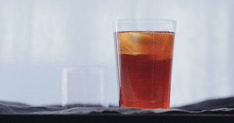 making cocktail aperetivo in tumbler glass with window on background