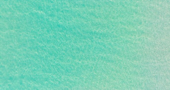 Water texture background Cinematic The clear water surface of the tropical sea reflects the sunlight, overlooking the white sand beneath the pure beauty of nature. Footage high quality 4K ProRes 422HQ