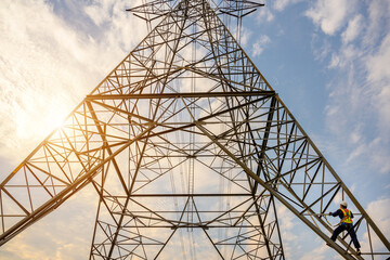 Electrician worker climbing electric pole at power station in order to inspect the operation of the high-voltage pylons