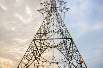 Male electrician climbing electric pole at power station Workers work to inspect the working system of high-voltage pylons.