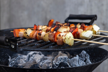 skewer with red pepper onion and smoked pork on a garden grill