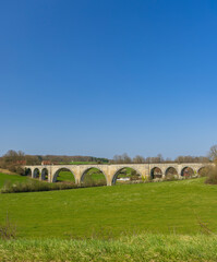 Fototapeta na wymiar Arched stone railway bridge onabandoned railway near Cognieres, Doubs, France