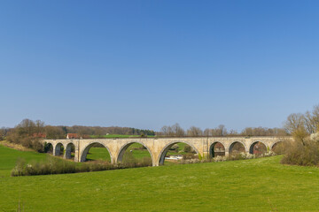 Fototapeta na wymiar Arched stone railway bridge onabandoned railway near Cognieres, Doubs, France
