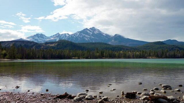Lake Annette lake shore beach, Pyramid mountain reflection on the lake. Jasper National Park stunning nature scenery in summer time. Landscape of Canadian Rockies, Alberta, Canada.