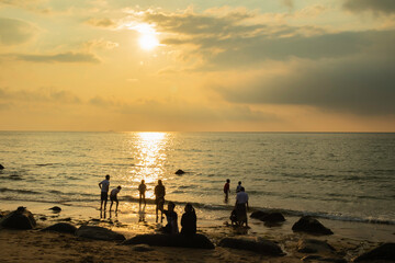 夕焼けの海と人々