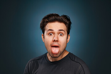 Fototapeta premium Young brunette man showing tongue emotional portrait