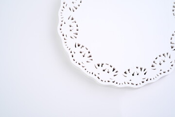 The round white napkin of frilly paper is isolated on white background, copy space. Macro shots