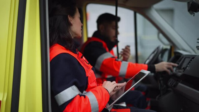 Team of rescuers preparing in ambulance car to outdoor operation.