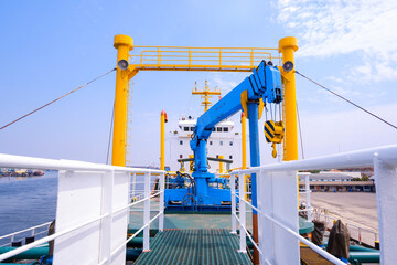 Blue crane on steel walkway over gas pipelines system in oil tanker ship at harbor