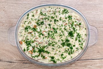Baked pieces of fish fillet in chanterelle cream sauce in a glass bowl.
