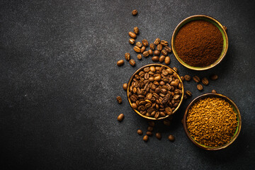 Obraz na płótnie Canvas Roasted coffee beans, ground coffee and instant coffee in bowls at dark background. Top view image.