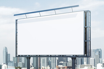 Obraz premium Blank white billboard on cityscape background at daytime, perspective view. Mock up, advertising concept