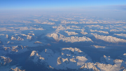 Flight over Greenland with landscape of white snow mountains