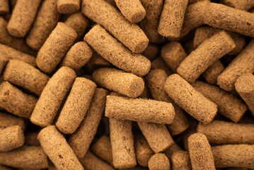 Food for animals and aquarium fish in grits on a white background. Pile of feed