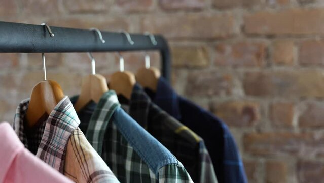 Clothes on wooden coat hangers hanging in a clothing store