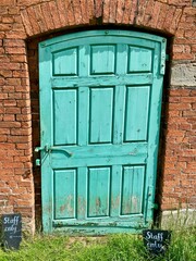 Rustic Green Door in Outside garden door. Calke Abbey, Derbyshire, UK. 2020.