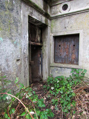 The entrance to an old abandoned world war I bunker at the Copenhagen defences, with clear vegetation raclaming much of the area 