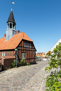 Das alte Rathaus von Ebeltoft, Djursland, D&auml;nemark aus Fachwerk, rotem Backstein und mit Turm in der Sonne vor blauem Himmel