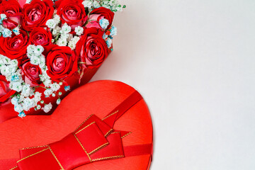 Bouquet of red roses in gift box in form of heart, top view, free space to copy text