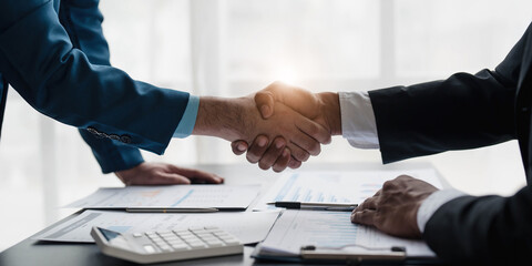 Business handshake for teamwork of business merger and acquisition,successful negotiate,hand shake,two businessman shake hand with partner to celebration partnership and business deal concept.