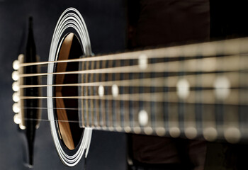 Fototapeta premium Guitar black, polished smooth soundboard, stretched strings, frets on neck, close-up selective focus