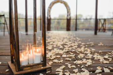 wedding decor at an outdoor ceremony, candles in glass, a path of rose petals
