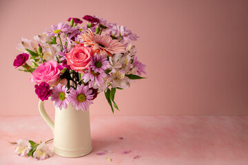 Beautiful fresh spring flowers. Pink bouquet of flowers in vase, on pink background. Copy space