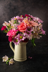 Beautiful fresh spring flowers. Pink bouquet of flowers in vase, on black background.