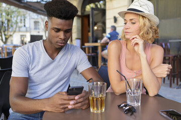 bored woman waiting for his boyfriend to stop his phone