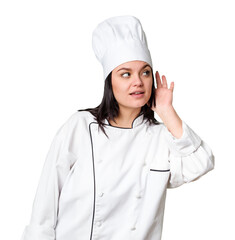 Young caucasian cook woman isolated trying to listening a gossip.