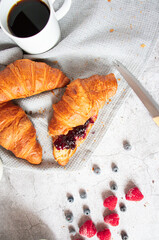 Breakfast with coffee and croissants, jam and berries. On a concrete background