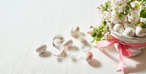Holiday composition with spring flowers and easter eggs in basket on a light background. Happy easter concept with copy space