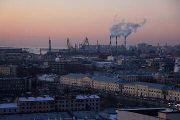 Industrial district of Saint-Petersburg: view of houses and smoking chimneys from a height at sunset