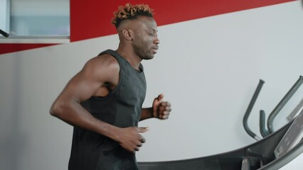 African American sportsman having a cardio workout on treadmill - Powered by Adobe