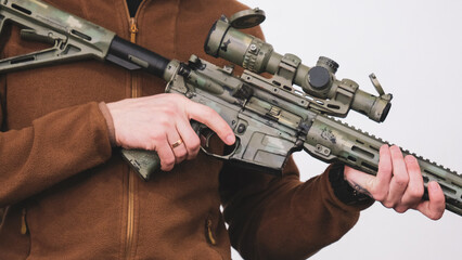 Soldier in a bulletproof vest with an American assault rifle, close-up details