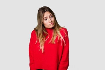 Young blonde posing for a portrait isolated, exuding natural beauty and radiance shrugs shoulders...