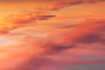 Gorgeous abstract view of pink and purple glowing cloudy sky after winter sunset. Magnificent colour shades of rolling clouds at the end of the day