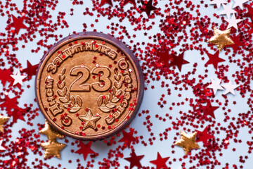 Obraz na płótnie Canvas Greeting card for the Defender of the Fatherland Day. The inscription is in Russian. White, gold, red stars, an iron medal with the date February 23 on a blue background. The holiday is February 23.