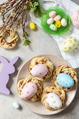 Easter composition. Sweet Italian Easter Bread Rings from puff pastry and dyed eggs on a stone background. View from above.