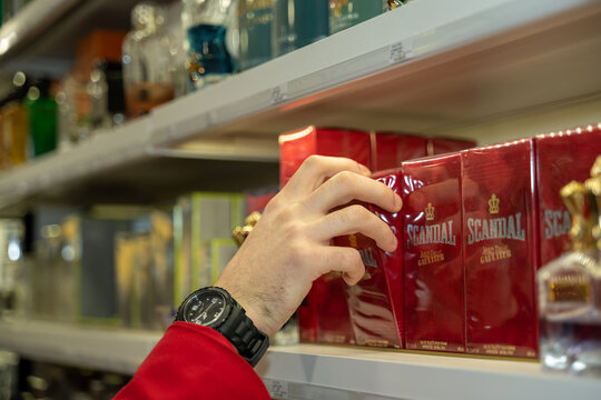 mains d'un homme choisissant un parfum masculin  dans une parfumerie