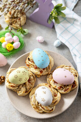 Easter composition. Sweet Italian Easter Bread Rings from puff pastry and dyed eggs on a stone background.