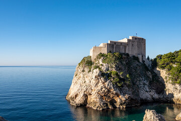 Fototapeta na wymiar Amazing Dubrovnik city fortified walls with Lovrinac stronghold on the highest rocky cliff above the sea