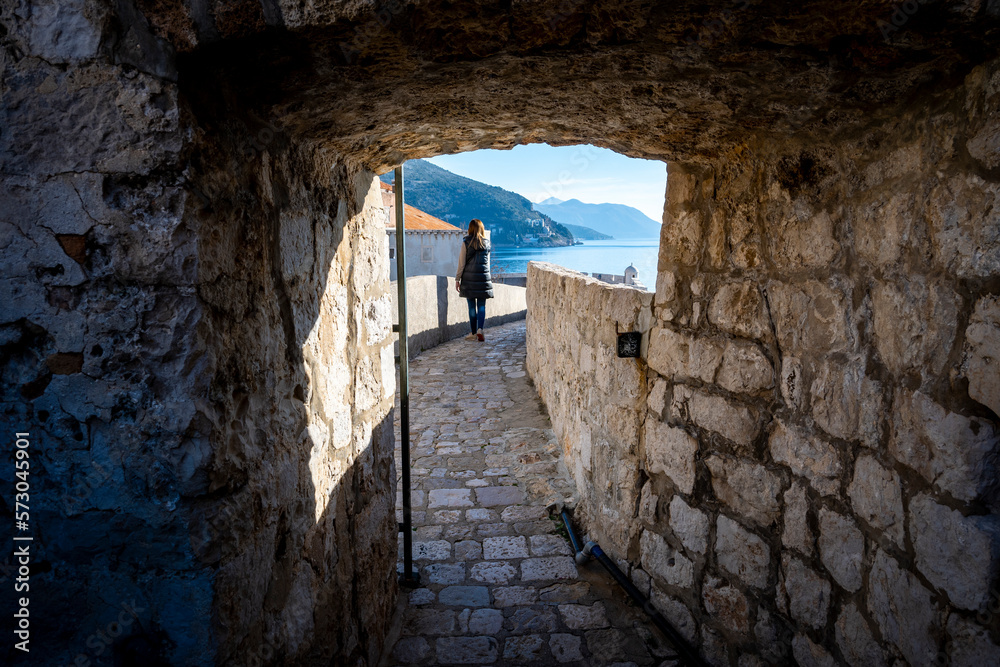 Canvas Prints Female tourist walking around famous Dubrovnik city walls during beautiful, sunny day on southern part of Dalmatian coast, Croatia