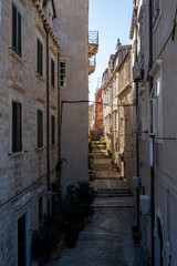 Fototapeta na wymiar Beautiful Dubrovnik city streets with old houses and vintage balconies suspended above the stone paved streets