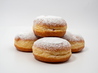 Freshly baked and dusted with powdered sugar German donuts. Donut berliner or krapfen on white background.