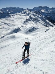 Fototapeta na wymiar A young man on ski tou. rSki mountaineering in an unbelievably beautiful mountain world. Swiss Alps. Ski touring in winter. Spitzmeilen Glarus. High quality photo