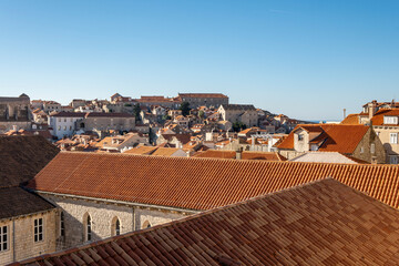 Wonderful Dubrovnik city red rooftops observed from old, stone defence walls that circle the city, now used as tourist attraction to see local landmarks